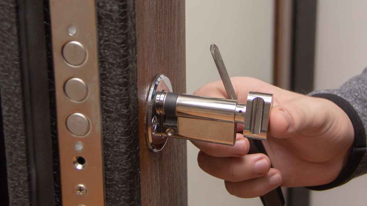 Mano cambiando cerradura puerta acto que dejo sin vivienda a inquilina 89 años Valencia