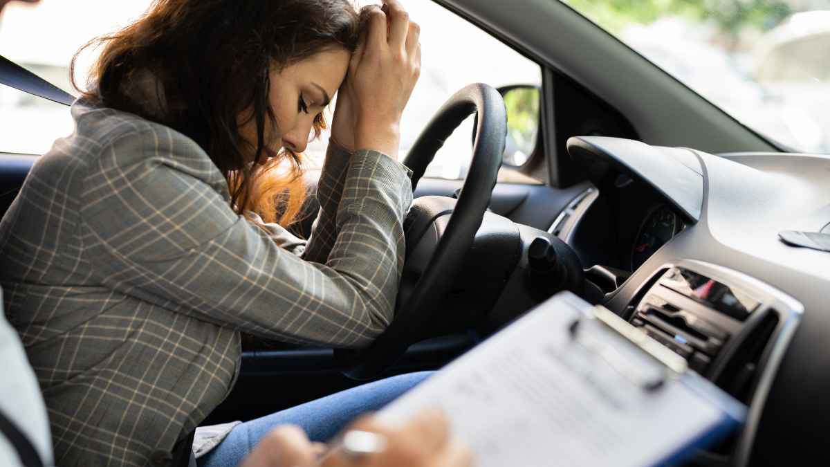 Mujer preocupada en el asiento de conductor entregando su carnet de conducir.
