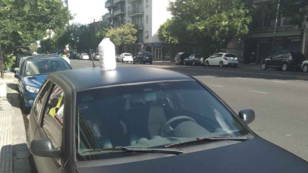 Botella de agua sobre el techo de un coche aparcado que indica, según el código callejero argentino, que el vehículo está en venta.
