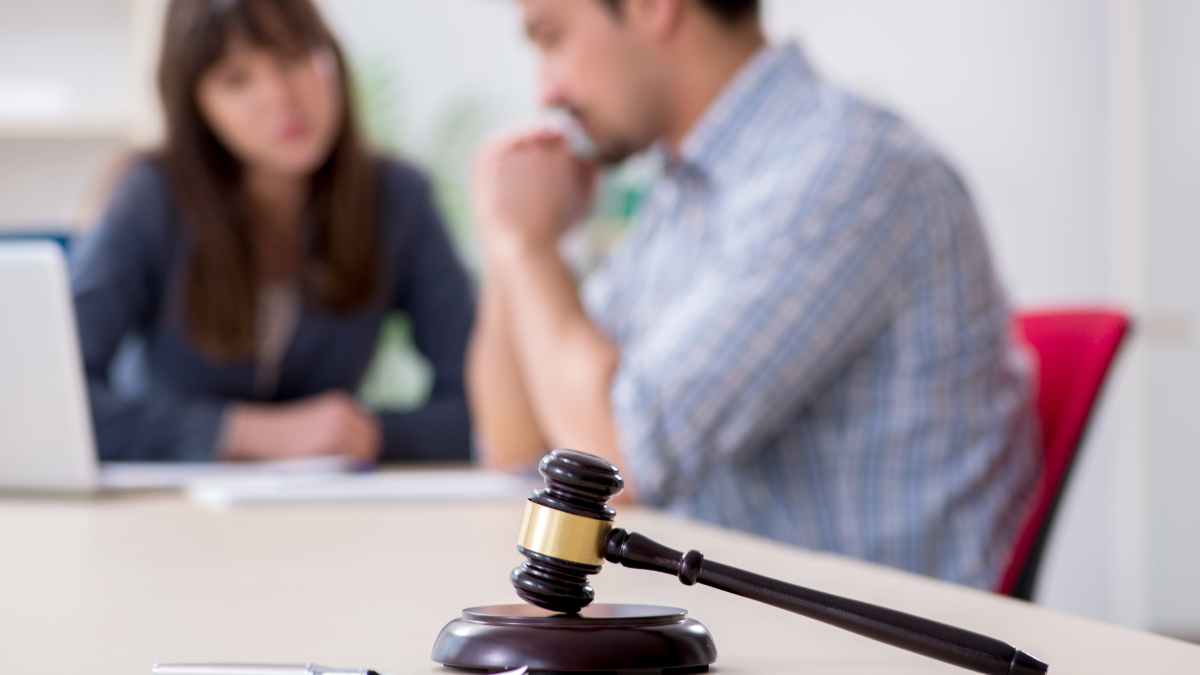 Mazo judicial sobre la mesa con conductor despedido y abogada al fondo