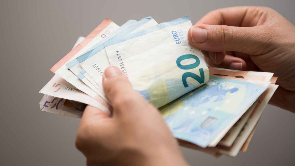 Manos contando billetes de euro que representan los 600 € de ayuda del SEPE por completar cursos certificados, estés trabajando o en paro.