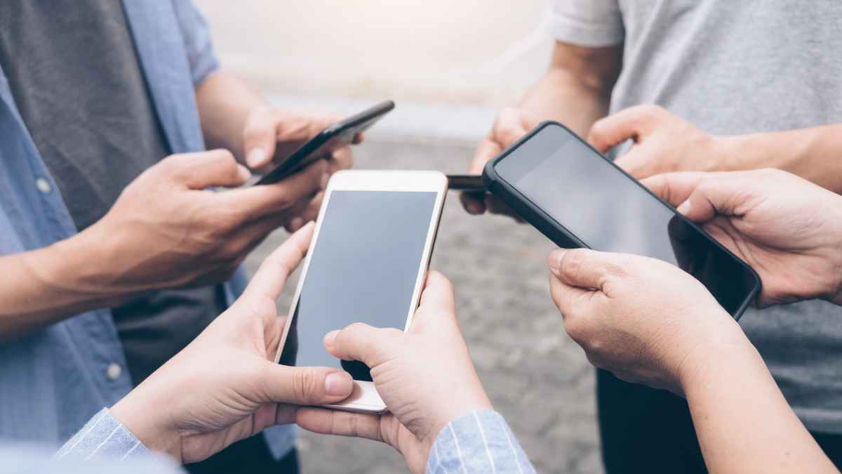 Personas con móviles ante posible estafa telefónica que suplanta a la Guardia Civil y la DGT
