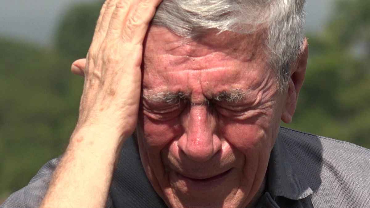 Hombre mayor angustiado con la mano en la cabeza al aire libre