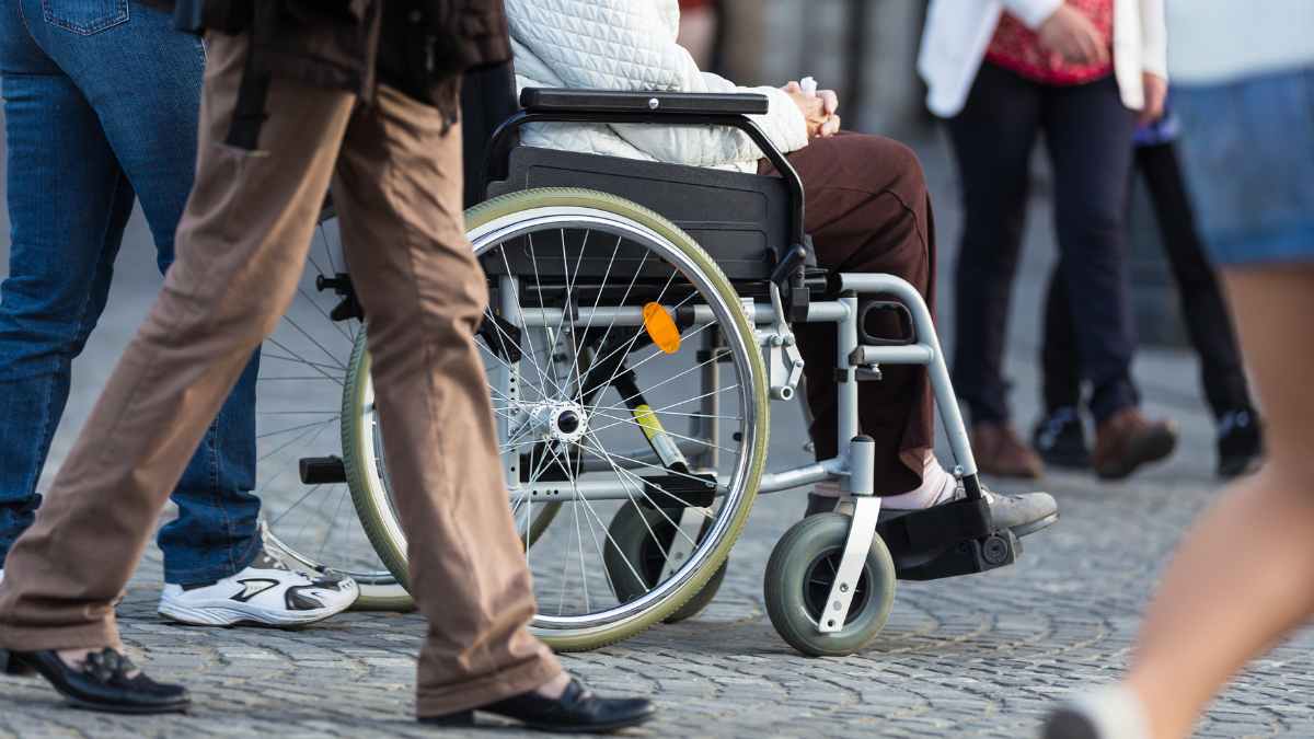 Trabajador en silla de ruedas por la calle: jubilación anticipada para puestos de riesgo según el Real Decreto 2025 en España