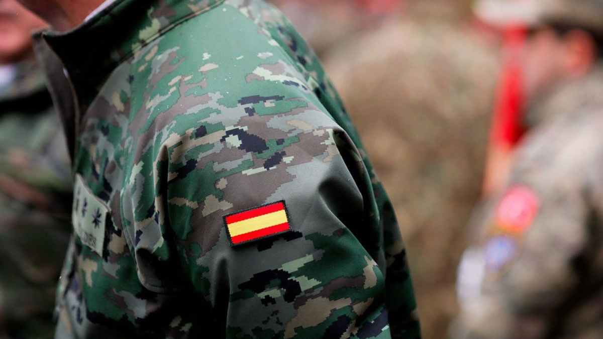 Soldado español con uniforme de camuflaje y bandera ilustrando la mili que cuenta para la jubilación anticipada
