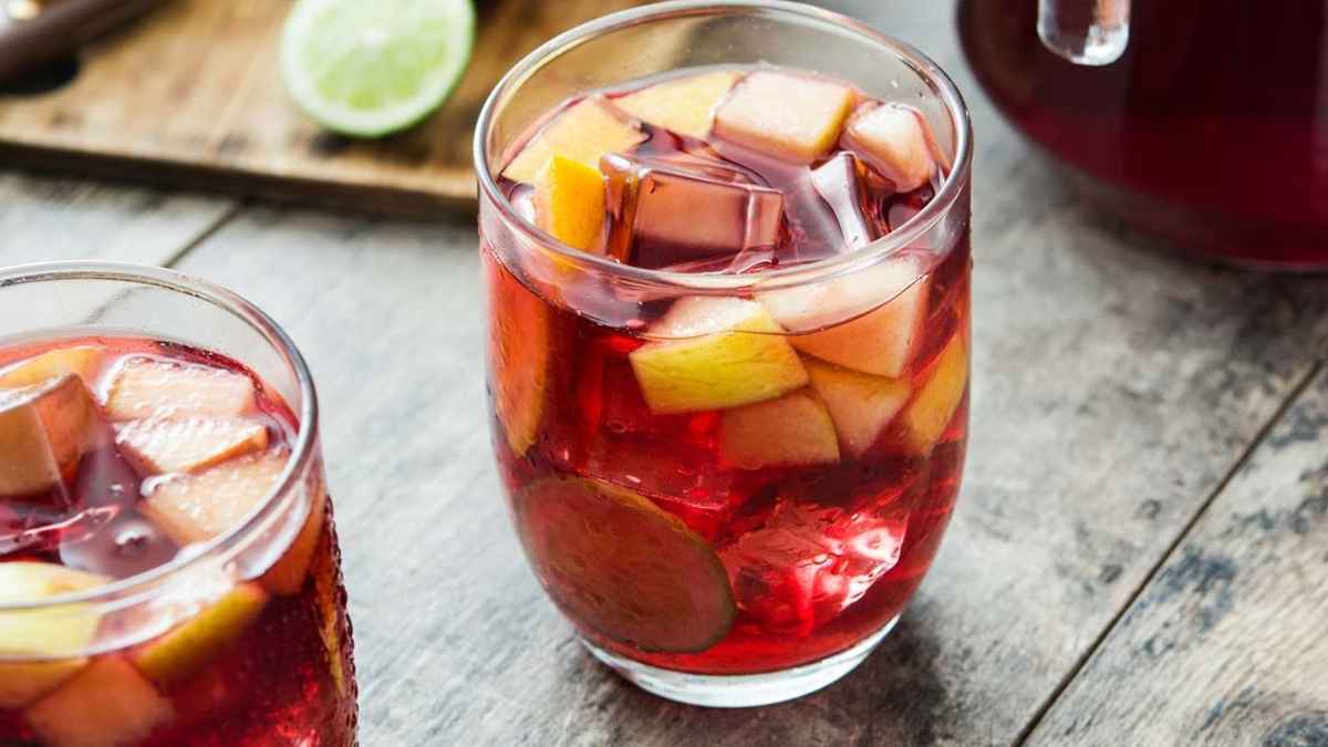 Tinto de verano con hielo y trozos de fruta en vaso sobre mesa de terraza de Santiago de Compostela.
