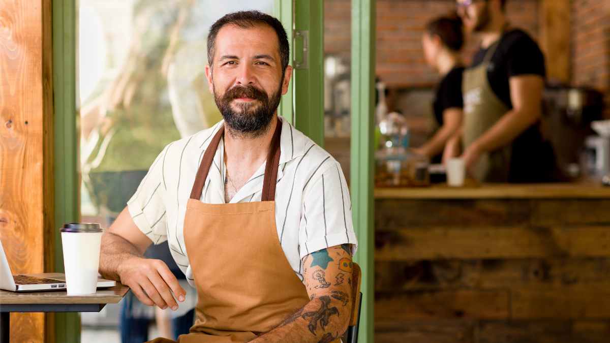 Trabajador de hostelería con delantal en cafetería, protagonista de sentencia por despido nulo durante su baja médica