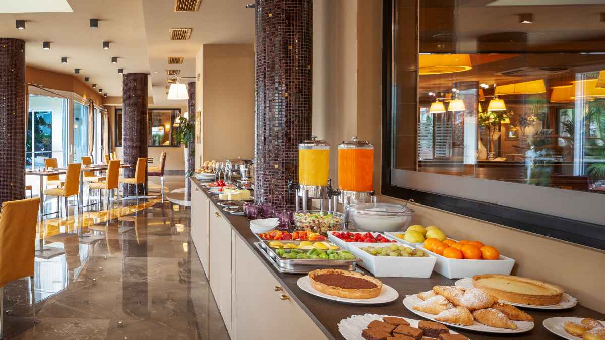Buffet de hotel todo incluido con zumos, frutas frescas y repostería, ejemplo práctico del “truco de los tres días”.