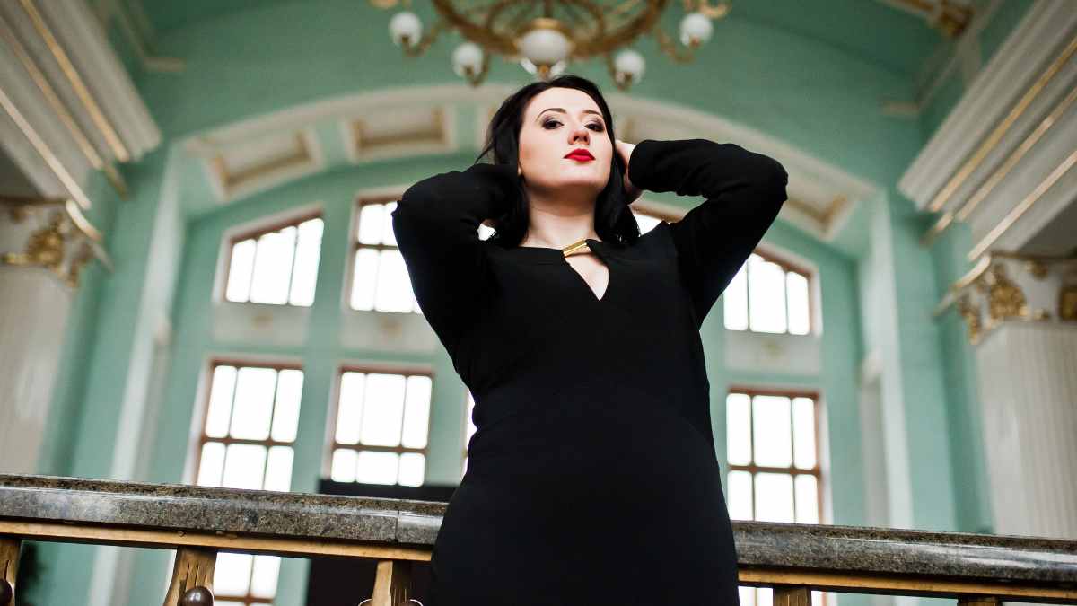 Mujer con vestido negro en un edificio elegante, representando el impacto psicológico del color negro en la vestimenta