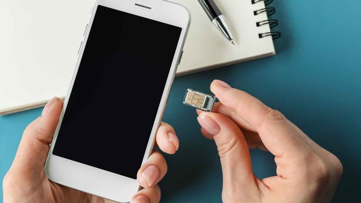 Persona retirando tarjeta SIM física del teléfono móvil antes de activar la eSIM