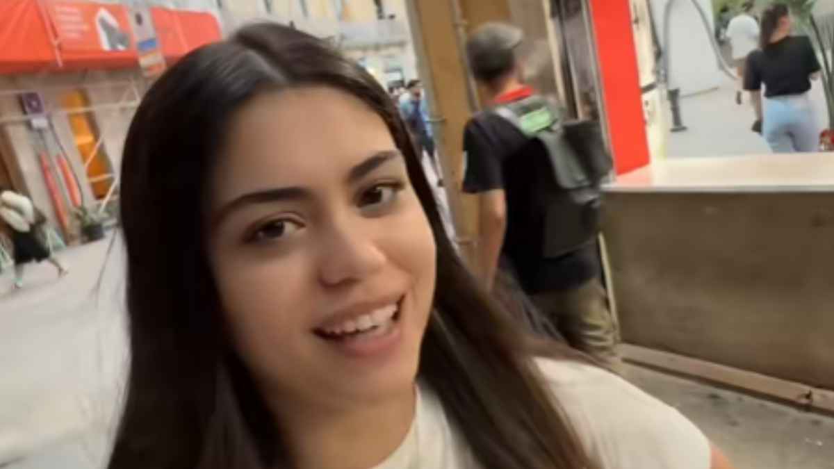 Turista argentina sonriendo mientras pasea por una calle de Barcelona en su primera visita a la ciudad