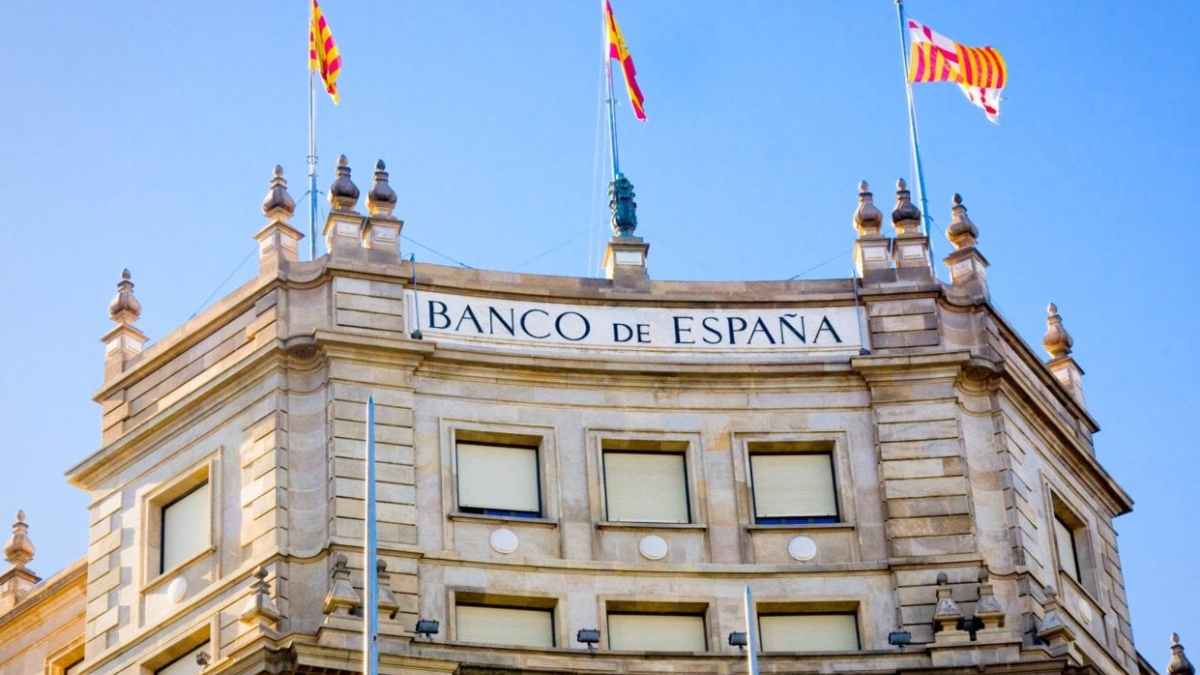 Fachada del Banco de España con bandera española, aviso sobre fraudes en alquileres