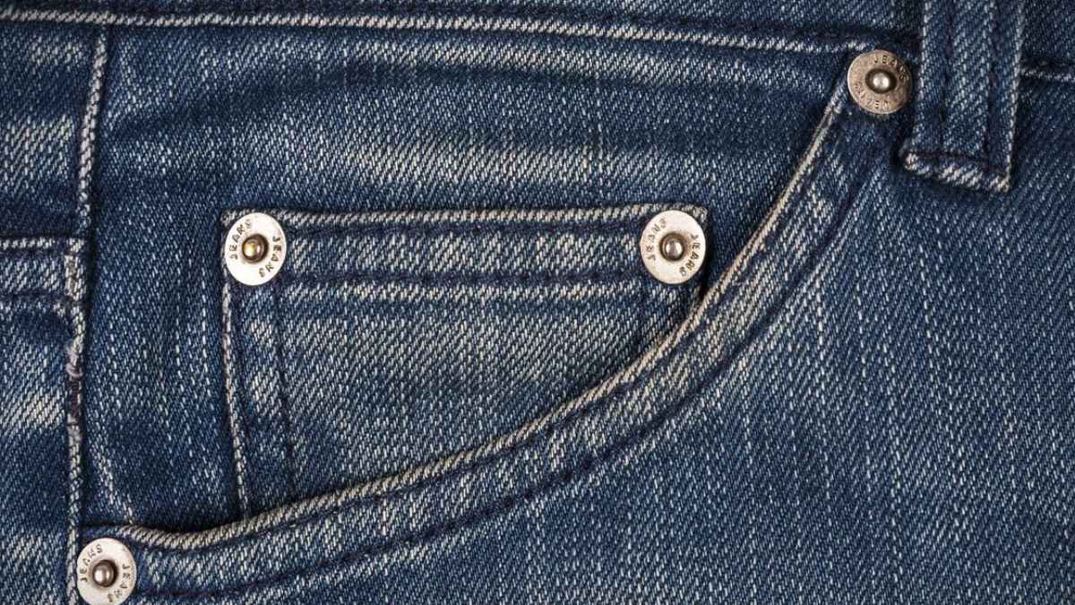 Detalle bolsillos vaqueros con botones metálicos que refuerzan costuras