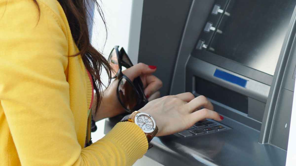 Mujer utilizando cajero automático accesible adaptado a la nueva normativa de la UE en España