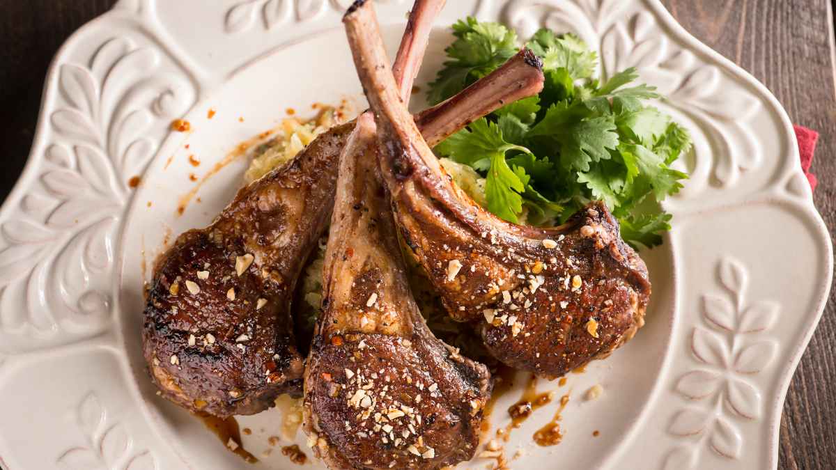 Plato de chuletillas de cordero lechal con guarnición servido en restaurante