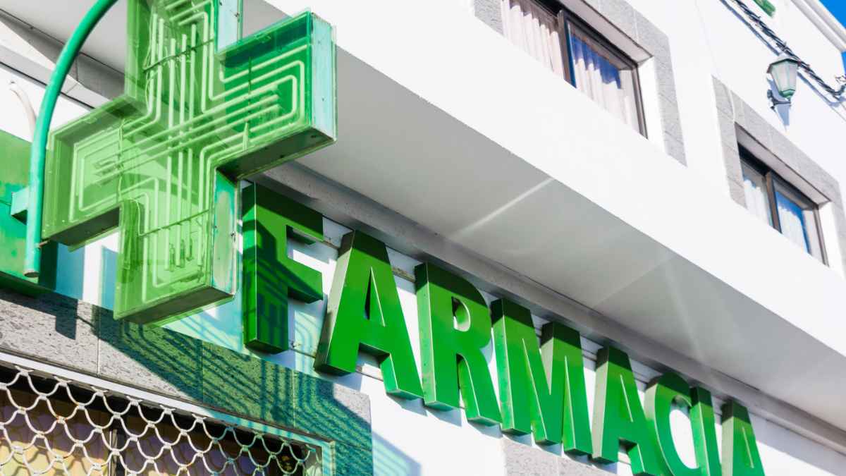 Fachada de la farmacia con cruz verde en Bérgamo donde el farmacéutico fue despedido tras 25 años sin cotizar.