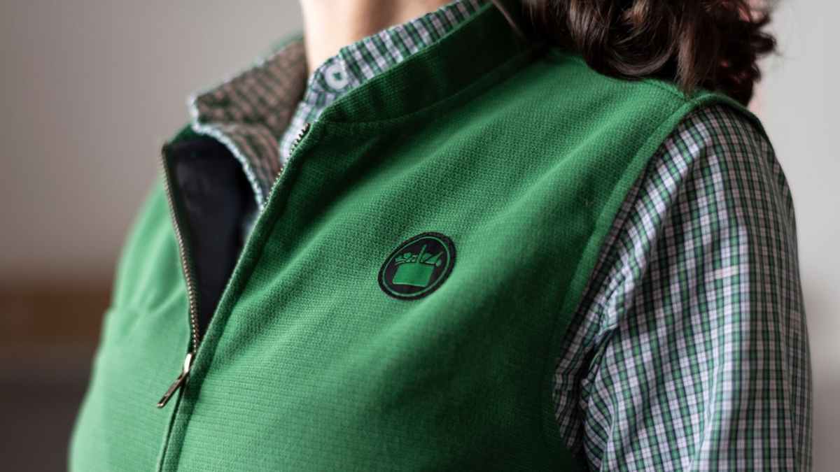 Uniforme de una gerente de Mercadona con chaleco verde y logo corporativo
