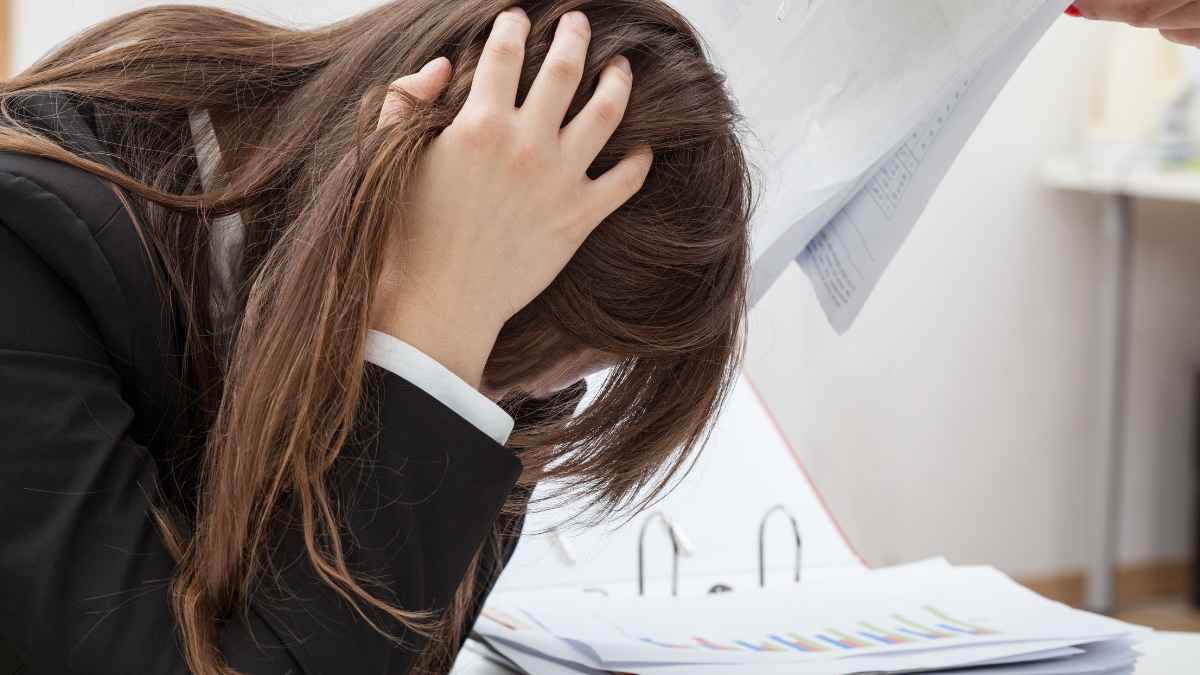 Estudiante extremeña con la cabeza entre manos tras difícil pregunta de sintaxis en la PAU, reflejando estrés por el examen.