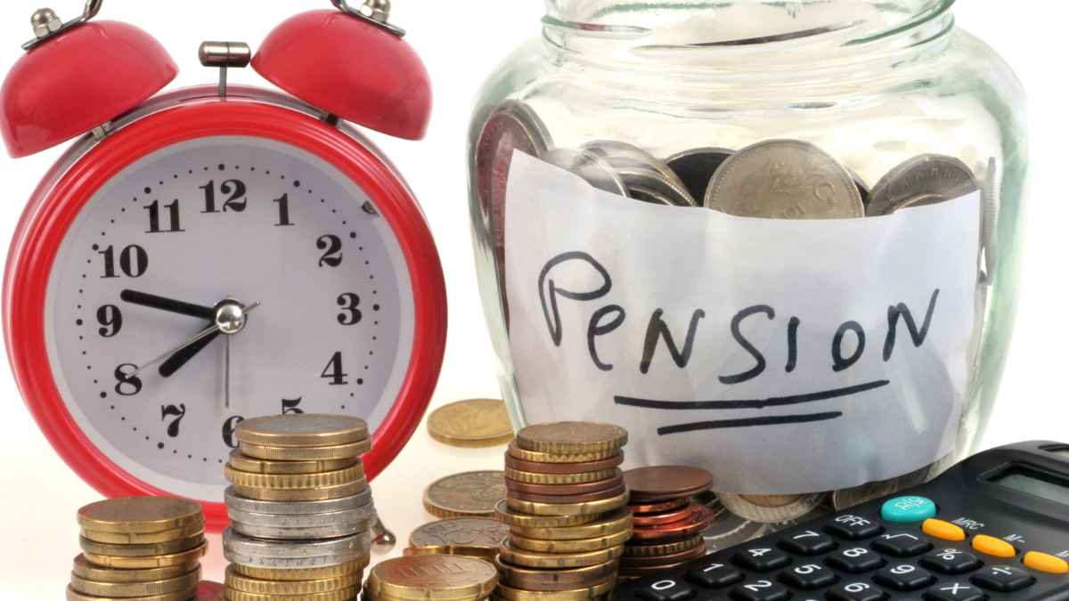 Hucha de monedas etiquetada “pensión”, reloj rojo y calculadora que ilustran la ayuda del IMSERSO de casi 12 000 € para pensionistas