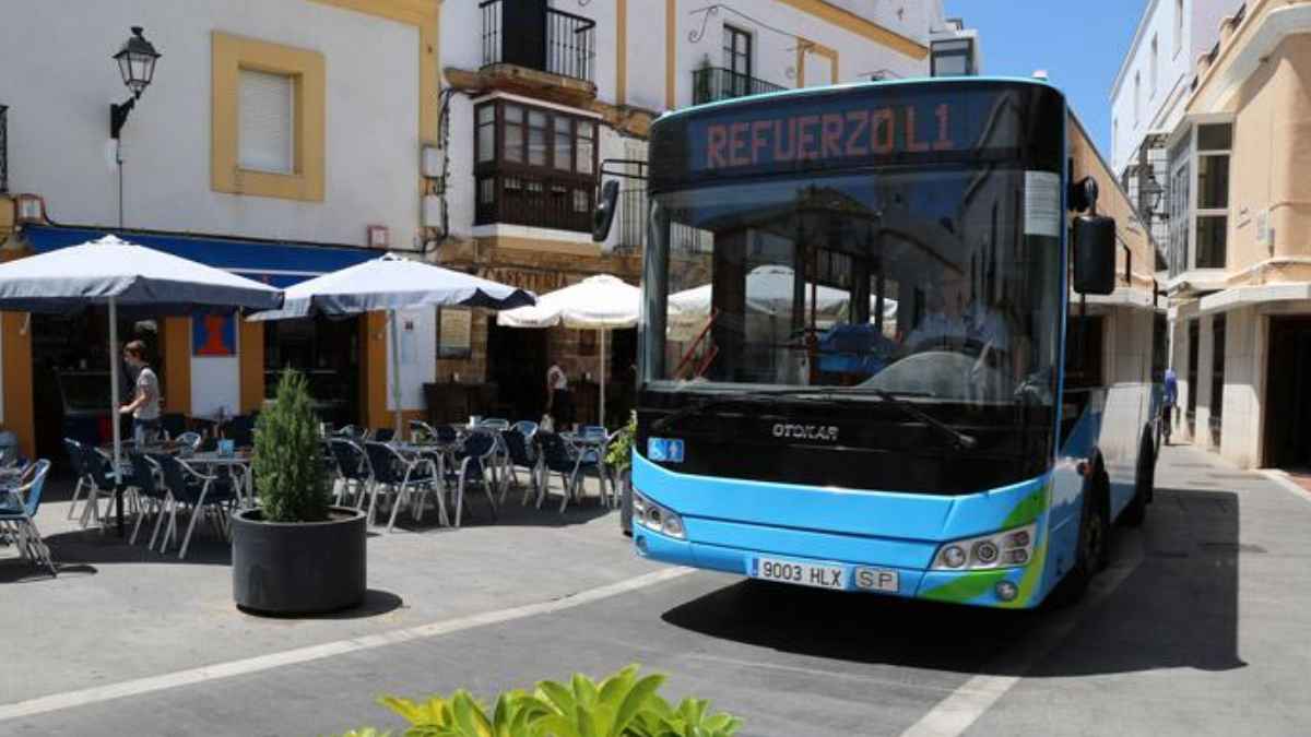 Autobús urbano azul en una calle andaluza anunciando “Refuerzo L1”, símbolo del transporte público gratuito para menores de 14 años con la Tarjeta Joven desde el 1 de julio.
