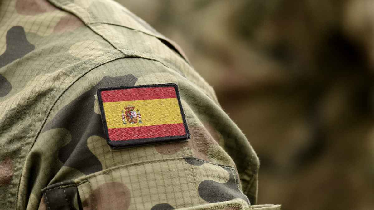 oldado con uniforme militar camuflado y parche de la bandera de España en el brazo