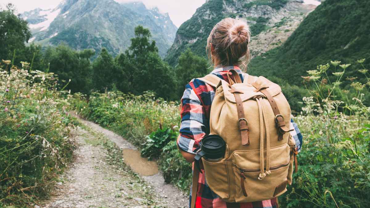 Mujer de espaldas con mochila practicando senderismo en los Picos de Europa durante baja médica por ansiedad