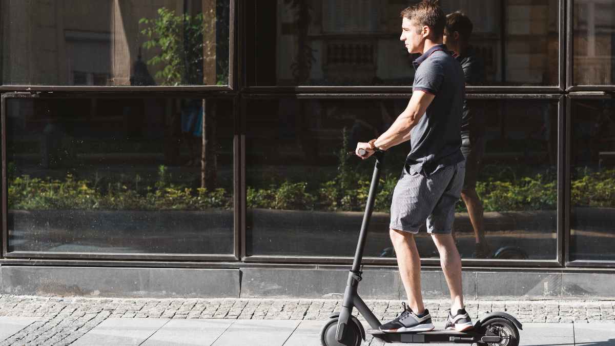 Hombre en patinete eléctrico circulando por la ciudad sin casco ni seguro