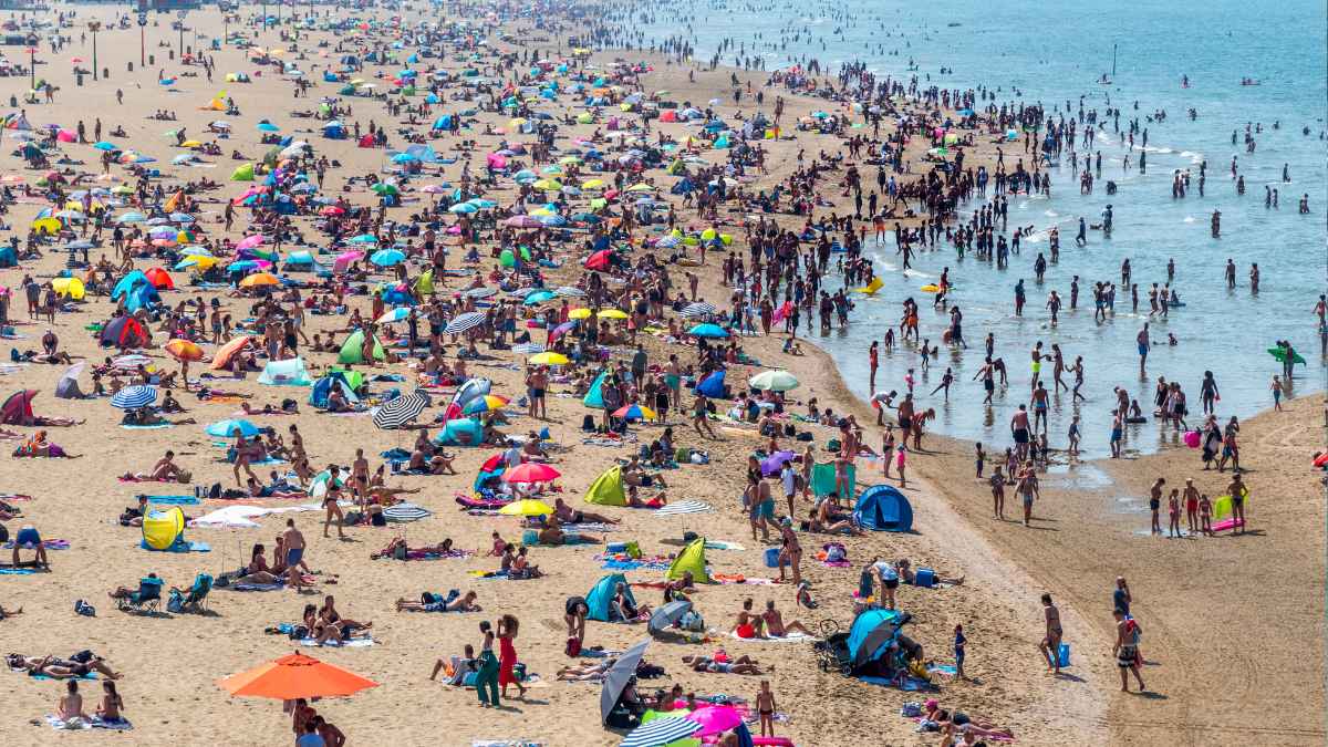 Bañistas en la playa bajo vigilancia municipal por nuevas normas y sanciones en España verano 2025