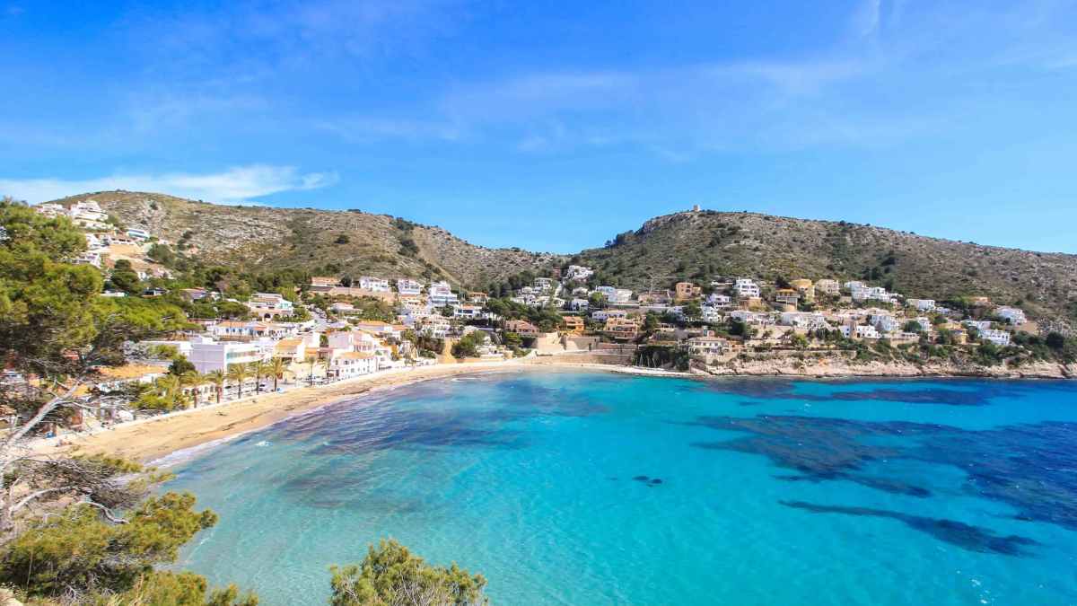 Rincón escondido de la Costa Blanca: vista de Moraira con arena dorada, aguas turquesa y casas entre viñedos