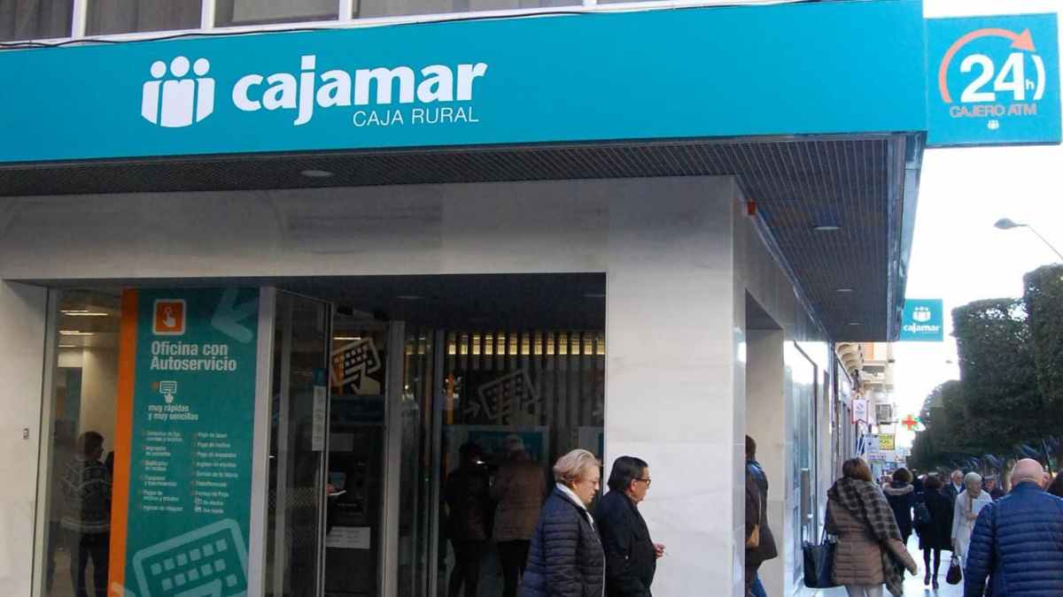 Fachada de una oficina de Cajamar con clientes, vinculada al despido del trabajador por un préstamo irregular