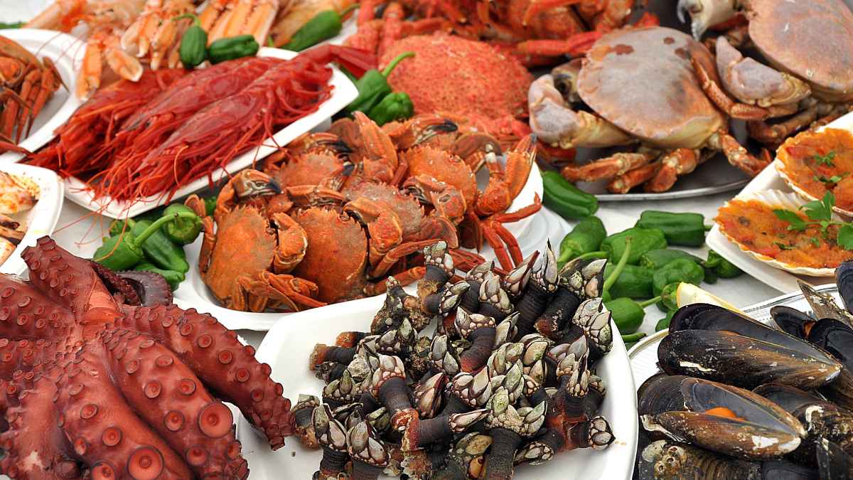 Bandeja de marisco con ostras, gambas rojas y cangrejos en restaurante de Bari, caso truco cigarro y bolso
