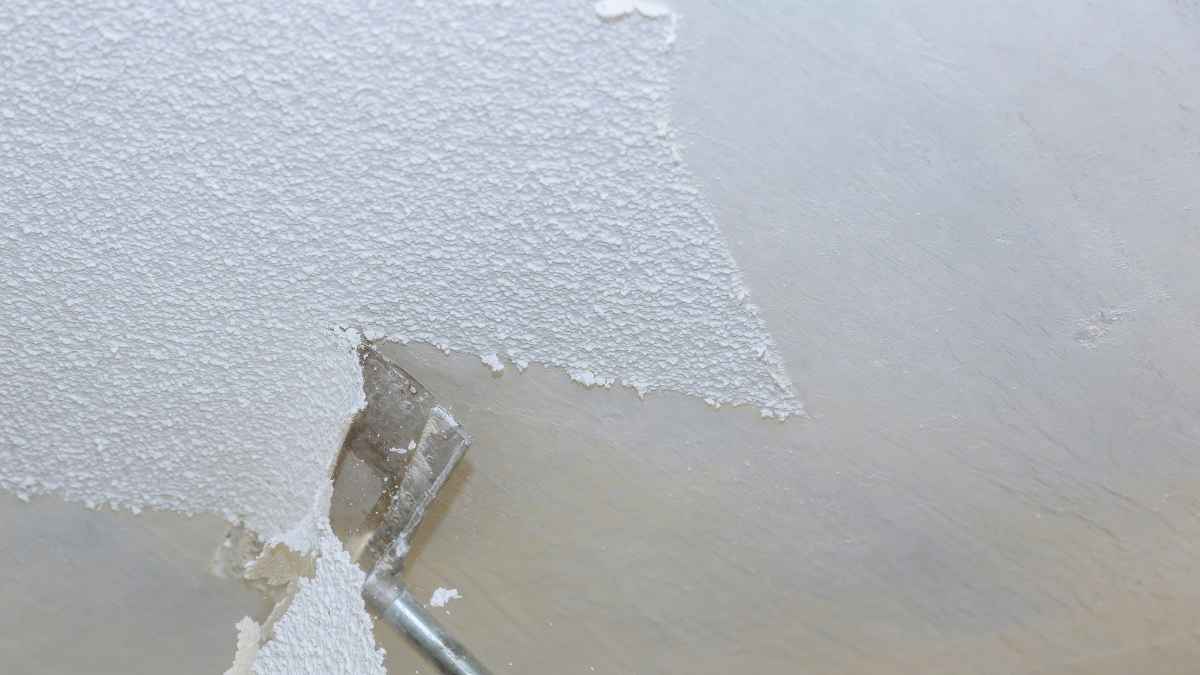 Espátula eliminando gotelé de una pared para dejarla lisa sin contratar profesionales