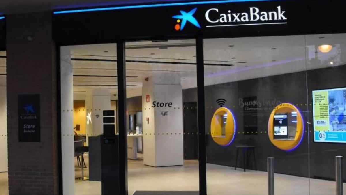 Oficina CaixaBank iluminada con logo visible en la entrada, entidad que ofrece 40.000 viviendas desde 27.600 euros en su nuevo portal inmobiliario Facilitea Casa