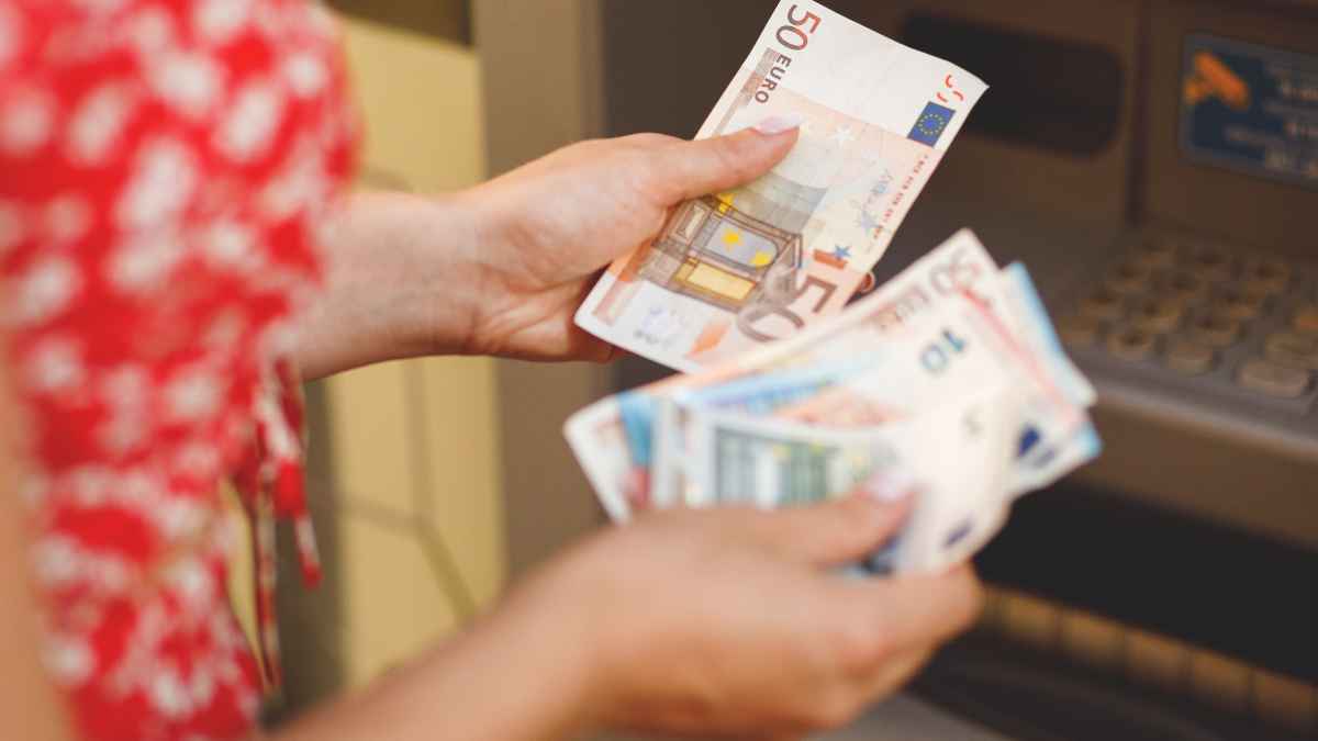 Persona sacando dinero en efectivo de un cajero automático tras los cambios por la nueva ley de accesibilidad en España