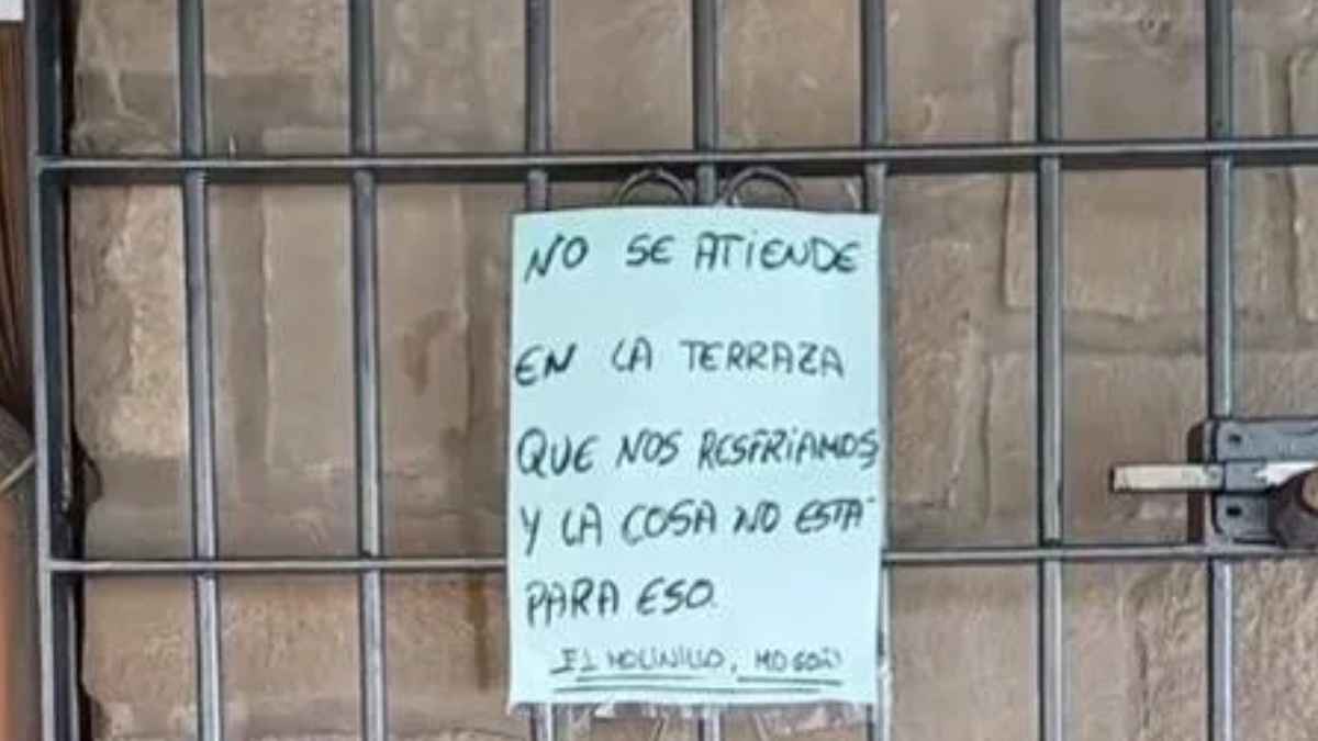 Cartel colgado en puerta de bar andaluz negándose a atender en terraza por frío