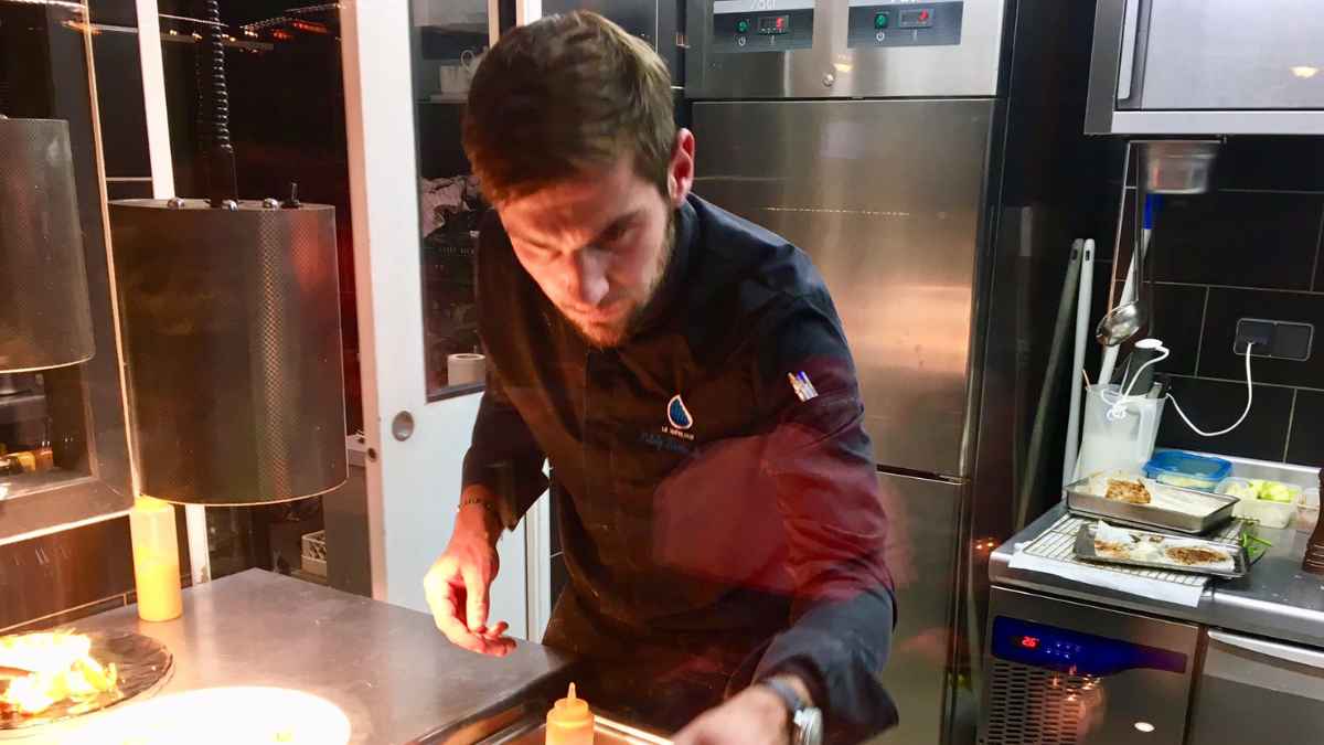 Chef preparando un plato en su restaurante antes de cerrarlo por turismo masivo y reservas limitadas
