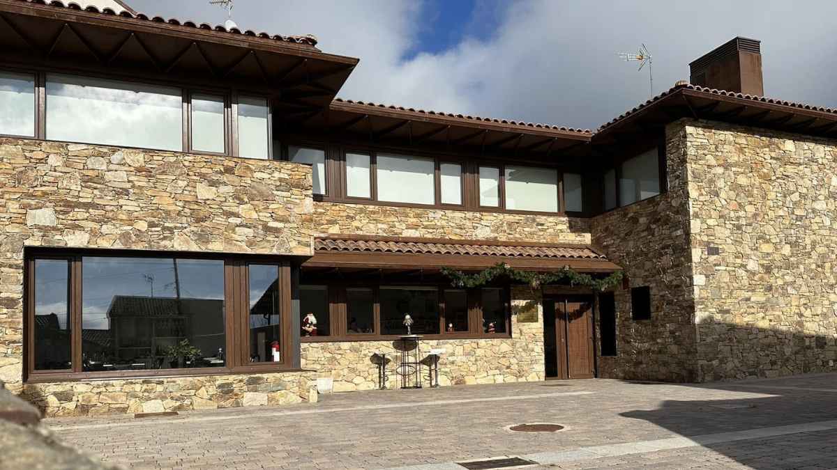 Exterior del edificio de piedra donde se encontraba el único bar en Cinco Villas, un pueblo madrileño que cerró, generando polémica.