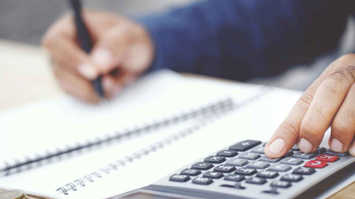 Mano usando calculadora para calcular el Impuesto de Sucesiones y aplicar el truco legal de cuatro años y medio