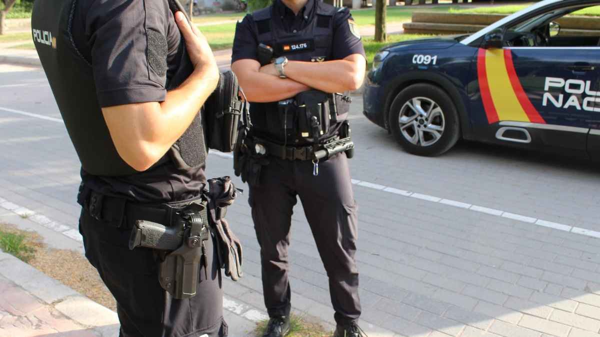 Dos agentes de la Policía Nacional junto a un coche patrulla, símbolo de la incorporación gitana a las fuerzas de seguridad.