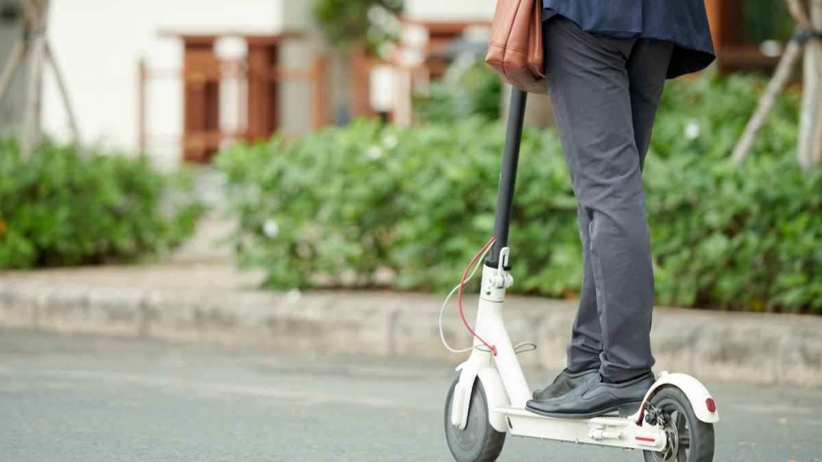 Persona usando patinete eléctrico blanco más vendido en AliExpress este verano