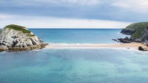 La playa cántabra donde una lengua de arena te hace caminar sobre el mar hasta un islote salvaje
