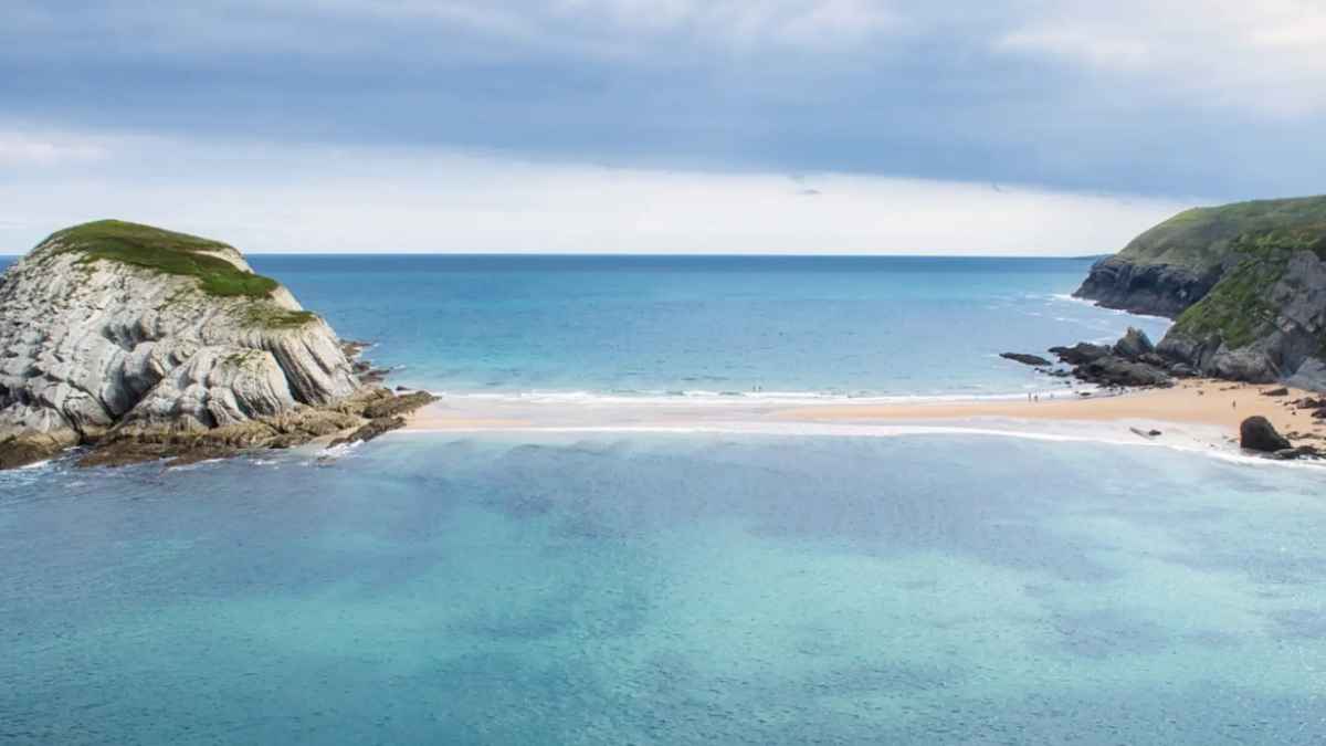 Vista aérea lengua de arena playa covachos Cantabria une orilla con Isla del Castro