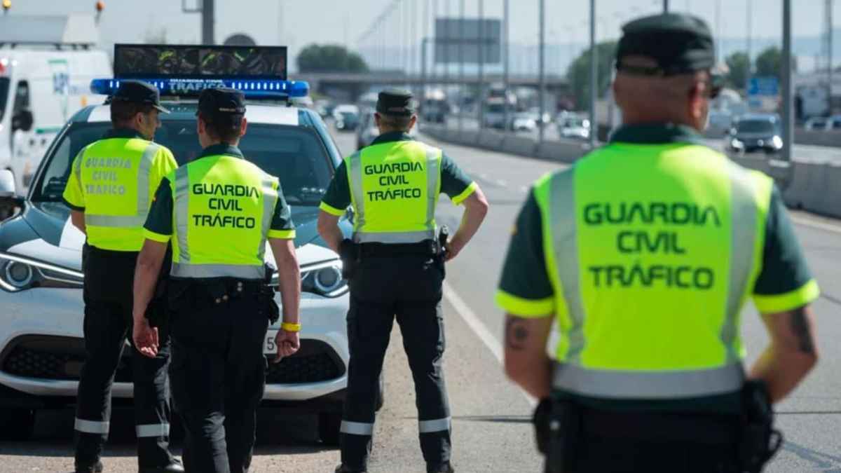 Guardia Civil de Tráfico en un control de carretera junto a un coche patrulla