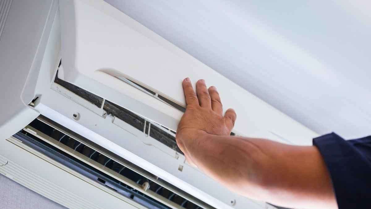 Técnico ajustando aire acondicionado split para ahorro energetico en verano
