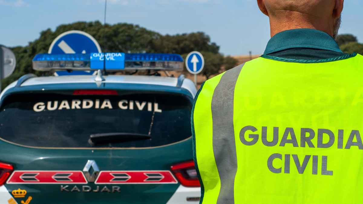 Agente de la Guardia Civil junto a patrulla controlando vehículos y enganches traseros con multas de hasta 500 euros