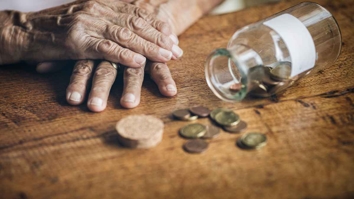 Impuesto de sucesiones y donaciones 2025: manos de persona mayor con monedas y tarro volcado, cambios y bonificaciones por comunidad