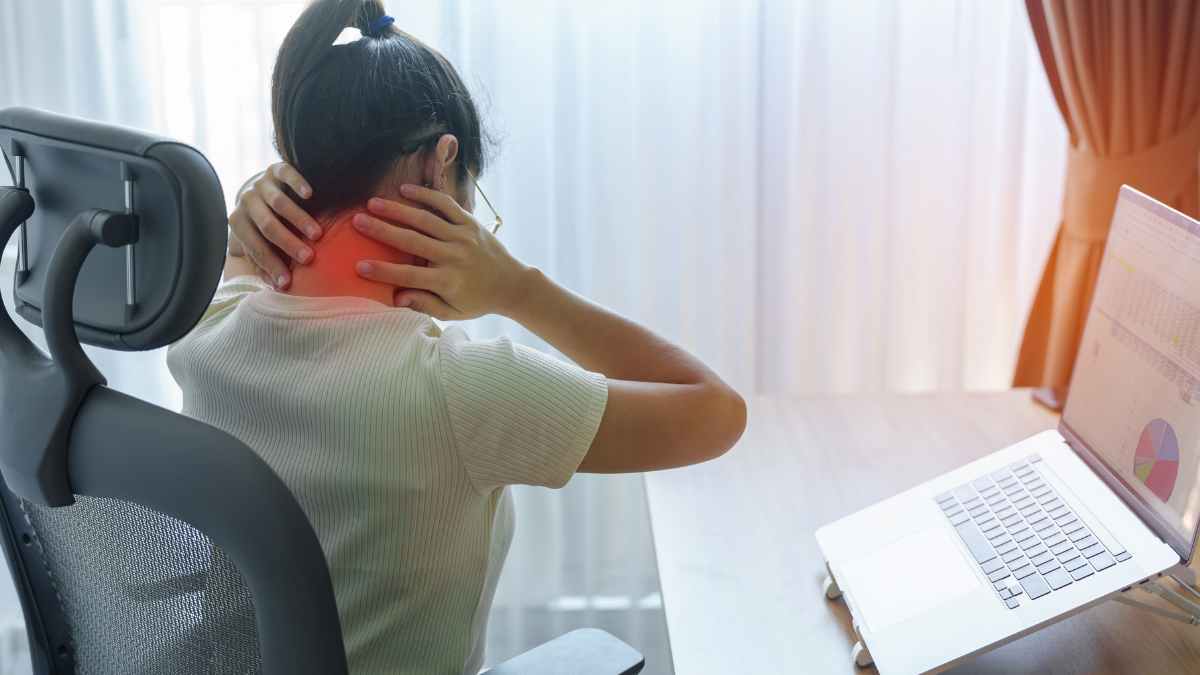 Mujer con dolor cervical relacionado con fibromialgia frente al ordenador