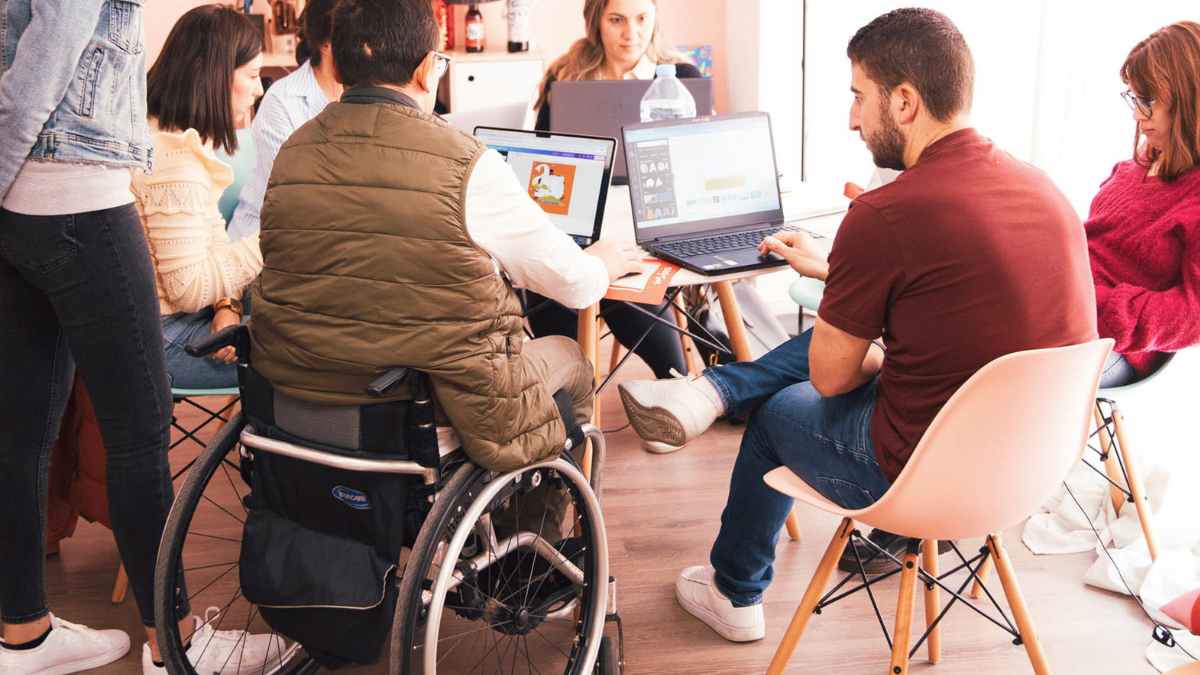 Persona con discapacidad trabajando en equipo, revisiones del INSS e incapacidad permanente en 2025
