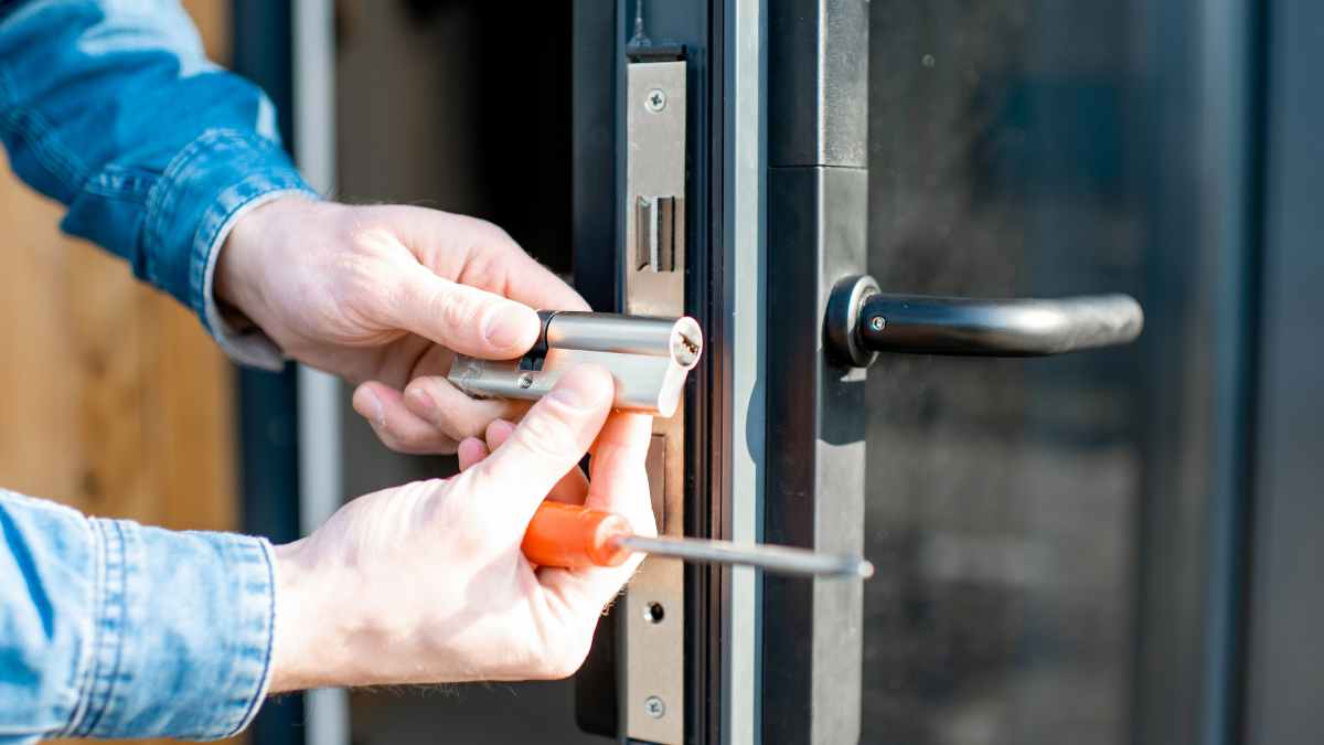 Inquilino cambiando la cerradura de la puerta de su vivienda de alquiler