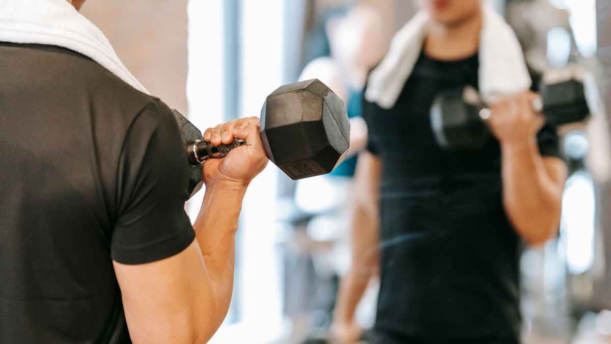 Entrenamiento con mancuernas en gimnasio, imagen de recurso sobre baja laboral